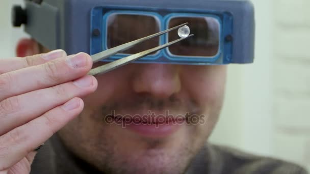Joalheiro usa óculos de proteção satisfeitos com a qualidade da jóia — Vídeo de Stock
