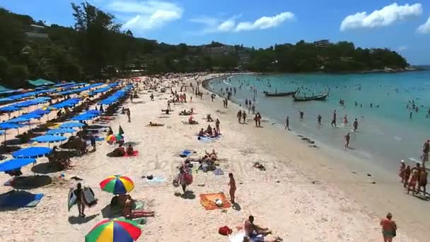 PHUKET, THAILAND - 20 JAN 2017: Vista aérea das pessoas nadam no mar perto da praia com espreguiçadeiras e guarda-sóis no dia ensolarado de verão — Vídeo de Stock