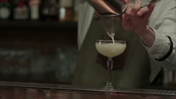 Deskundige barman is gieten in shaker cocktail met een glas voorbereid en zet het op servet in nachtclub — Stockvideo