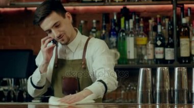 Bar sayaç silme ve cep telefonu ile konuşurken barmen