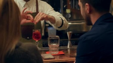 Barmen hizmet alkollü kokteyl yakışıklı bir adam için onun arkasında güzel bir sarışın kadınla alkış