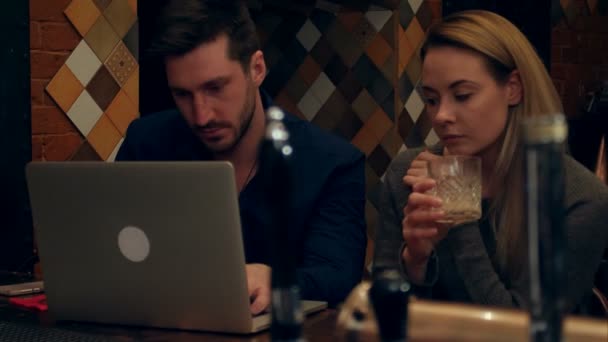Mensen uit het bedrijfsleven met behulp van laptop en niet-alcoholische cocktails drinken in staaf — Stockvideo