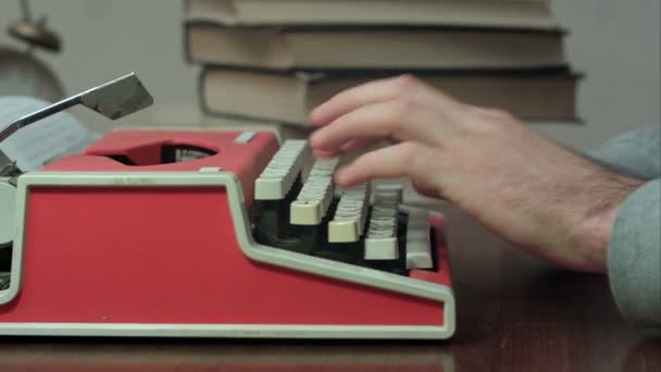 Επανδρώνει τα χέρια πληκτρολογώντας σε μια γραφομηχανή κόκκινο — Αρχείο Βίντεο
