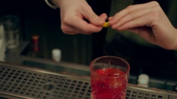 Barman hand voltooien de cocktail, het versieren met schijfje sinaasappel — Stockvideo