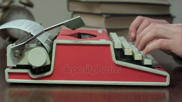 Mans mains tapant sur une machine à écrire mécanique rouge 