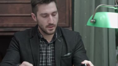 Masada oturan ve telefon görüşmesi cevap yazıyı okuyan genç editörü