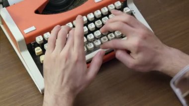 Eski bir kırmızı mekanik daktiloda yazmaya elleri mans
