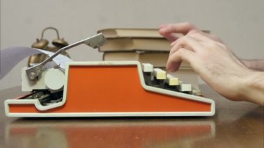 Kitap bir masada kırmızı bir retro daktilo yazarak eller mans