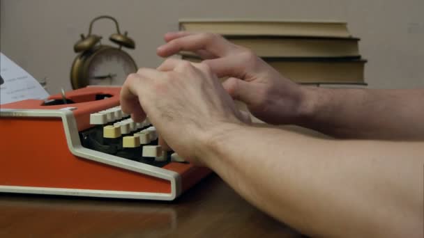 Mans hands typing on a red retro typewriter — Stock Video