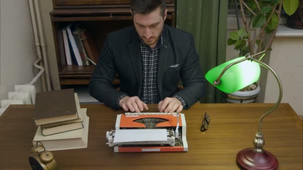 Konzentrierter Schriftsteller tippt neues Buch auf roter Vintage-Schreibmaschine in seinem Kabinett — Stockvideo