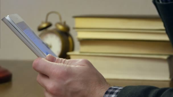 Mannetjes hand met digitale tablet met boek stapel op het Bureau — Stockvideo