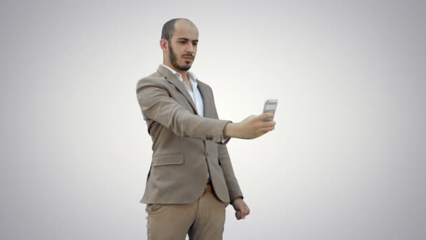 Giovane uomo d'affari scattare selfie al telefono su sfondo bianco . — Video Stock