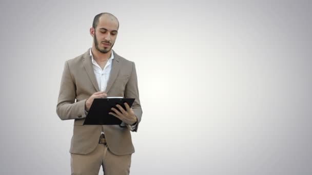 Homme d'affaires tenant presse-papiers et présentant un rapport d'entreprise sur fond blanc . — Video