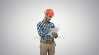 İnşaat planı beyaz arka plan üzerinde kontrol kask içinde genç mühendis.