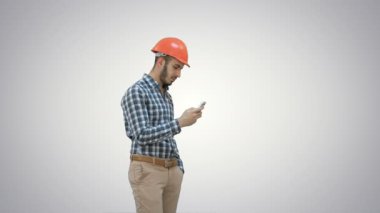 Cep telefonunuzun ve beyaz arka plan üzerinde kask içinde genç Yöneticisi.