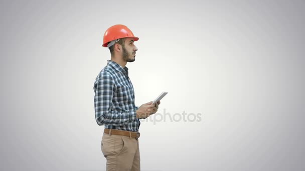 Engenheiro contratado em hardhat inspecionando canteiro de obras segurando tablet digital em fundo branco . — Vídeo de Stock