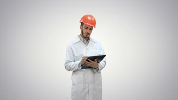 Ingenieur in witte jas voorbereiding verslag op witte achtergrond. — Stockvideo