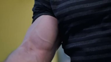 Bir adamın bir spor salonunda dumbbells ile egzersiz kas pazı