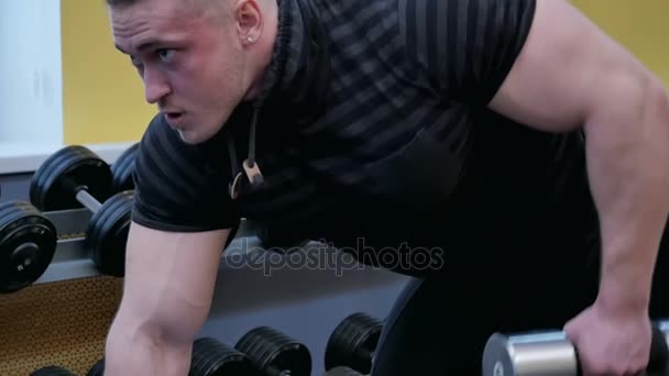 Atletik nüfuzlu bir spor salonunda dumbbells ile egzersiz yaparak — Stok video