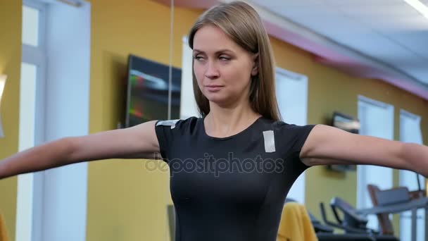 Молодая женщина работает с гантелями в тренажерном зале — стоковое видео