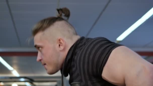 Joven musculoso haciendo ejercicio en el gimnasio — Vídeos de Stock