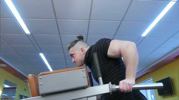 Νεαρός μυώδης άνδρας κατά τη διάρκεια της προπόνηση στο γυμναστήριο — Αρχείο Βίντεο
