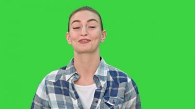 Neşeli genç kadın bir kamera için Chroma anahtar yeşil ekran söz.