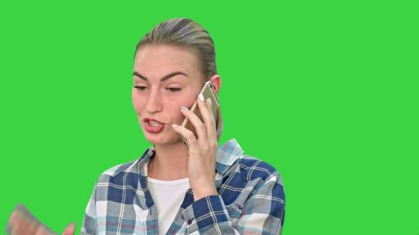年轻漂亮的女人谈认真地在绿色屏幕，色度键移动电话. — 图库视频影像