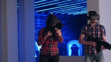 Genç kadın ve adam Vr sanal gerçeklik silah ve vr gözlük shooter oyun oynuyor