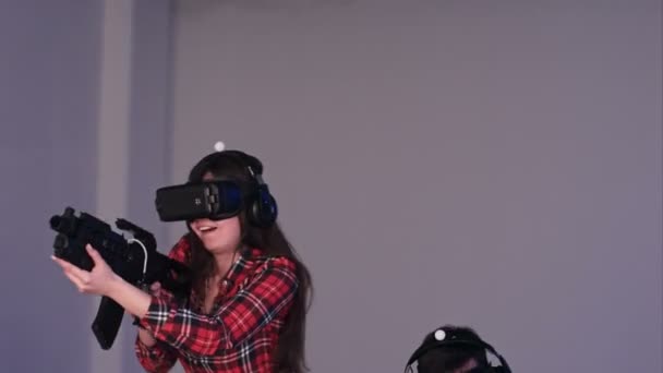 Jovem casal excitado vestindo óculos VR jogando jogo de tiro realidade virtual — Vídeo de Stock