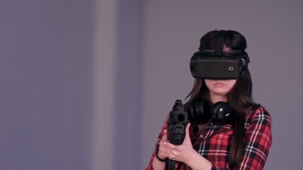 Chica usando gafas de realidad virtual y sosteniendo una pistola vr — Vídeos de Stock