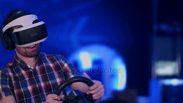 Homem feliz e animado jogando videogame de corrida com fone de ouvido realidade virtual — Vídeo de Stock