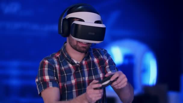 Feliz jugador hombre jugando videojuegos con auriculares de realidad virtual y joystick — Vídeo de stock