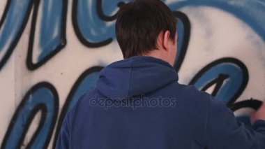 Bir duvar bir sprey ile erkek sanatçı grafiti çizim olabilir