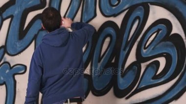 Genç kentsel ressamın duvara grafiti çizim