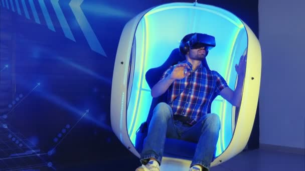 Jeune homme plongé dans l'expérience de la réalité virtuelle assis dans une chaise mobile — Video