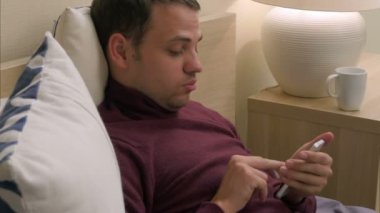 Adam yatakta uykusuzluk nedeniyle smartphone kullanarak