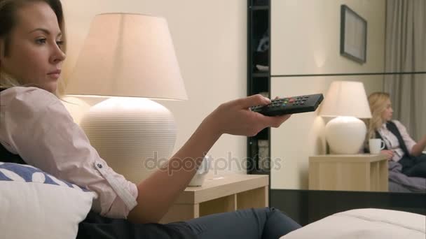 Femme interrupteur à main Chaînes de télévision au lit — Video