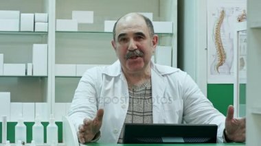 Üst düzey eczacı eczane dükkanda tavsiye tıbbi tedavi tıp sunan bir kamera konuşmak