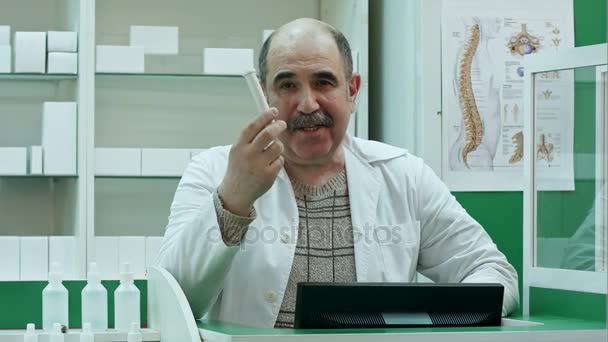 Friendly male pharmacist dispensing medicine holding a box of tablets — Stock Video