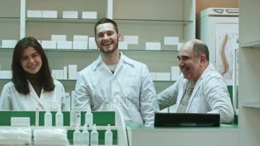 Kameraya bakarak bir eczane gülüyor üç yetkili Eczacılar