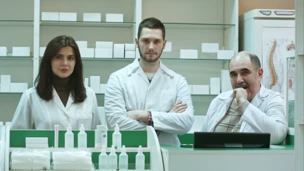 Equipo positivo de farmacéuticos mirando la cámara en la farmacia del hospital — Vídeo de stock