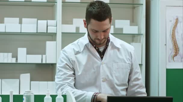 Retrato de un joven farmacéutico masculino mirando a la cámara y sonriendo — Vídeos de Stock