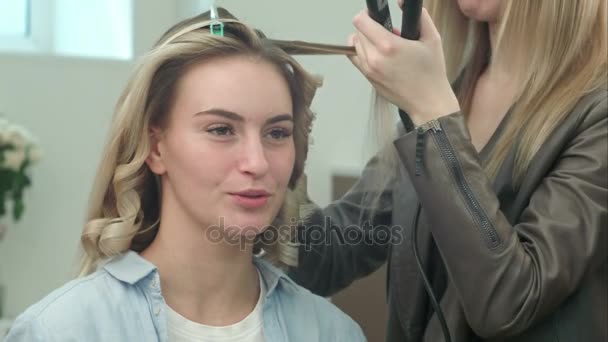 Professionell frisör använda hår rakt järn plattång hår, medan man pratar med klienten — Stockvideo