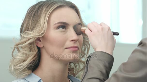 Aplicando maquillaje rubor con pincel a los pómulos de la joven sonriente — Vídeos de Stock