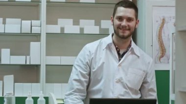 Beyaz önlük başparmak gösterilmesini ve okey gülümseyen erkek eczacı jest eller