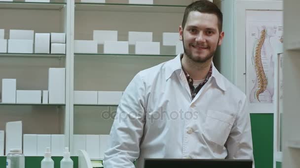 Usmívající se muž lékárník v bílém plášti zobrazující palce a fajn rukou gesto — Stock video