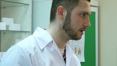 Bir kutu bir istemciye sunma tablet tutan erkek eczacı el