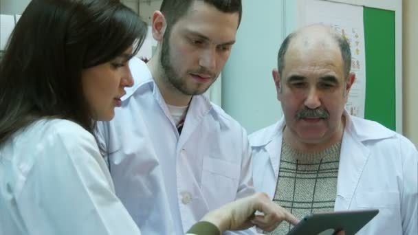 Farmacêuticos que utilizam comprimidos digitais enquanto verificam medicamentos na farmácia — Vídeo de Stock