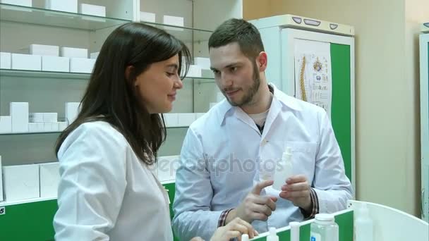 Equipe de farmacêuticos olhando para a medicina e conversando na farmácia do hospital — Vídeo de Stock